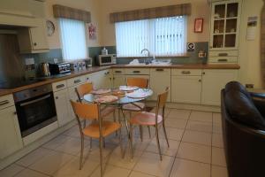 a kitchen with a table and chairs in it at Corunna Garden Cottage in Inverness