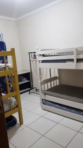 ein Zimmer mit einem Etagenbett und einem weißen Fliesenboden in der Unterkunft Apto. De frente pro Mar in Praia Grande