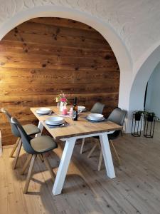 un tavolo e sedie in legno in una stanza con una parete in legno di Zur alten Post Zittau a Zittau