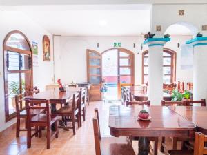 a restaurant with wooden tables and chairs and windows at Hotel Villa Real II in San Crist&oacute;bal de Las Casas