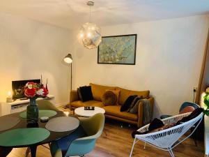 uma sala de estar com um sofá, uma mesa e cadeiras em Zonnebos, private garden, fresh air, relax! em Otterlo