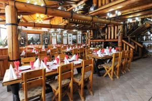 a restaurant with wooden tables and chairs with napkins on them at Gura Diham in Buşteni