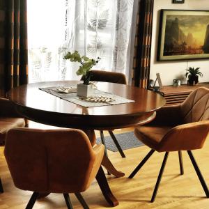 ein Esszimmer mit einem Holztisch und Stühlen in der Unterkunft Birdland Apartman in Bük