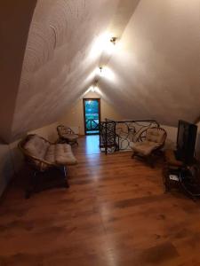 an attic room with chairs and a room with a door at Zielona Mila Dom Wakacyjny in Cekcyn