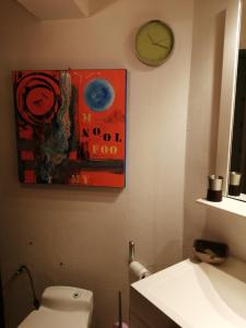baño con reloj en la pared y aseo en Studio Bar sur Mulhouse Sud, en Illfurth