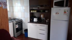 a kitchen with a white refrigerator and a stove at Cabañas Cadiz Valdivia in Valdivia