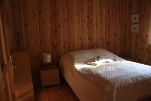 1 dormitorio con cama y mesita de noche con lámpara en Czerwony Domek, en Tleń