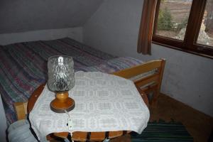 a small table with a lamp on it next to a bed at Auru Cīruļi in Auri +21 photos