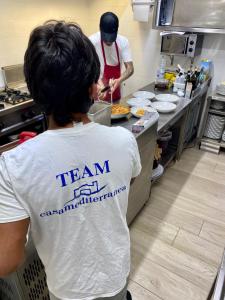 two people standing in a kitchen preparing food at Casamediterranea in Sperlonga