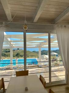 a dining room with a table and a view of a pool at Casamediterranea in Sperlonga