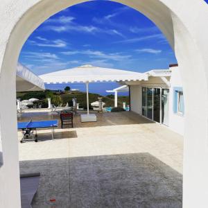 an archway leading to a patio with an umbrella at Casamediterranea in Sperlonga