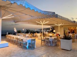 a restaurant with tables and chairs under a large umbrella at Casamediterranea in Sperlonga