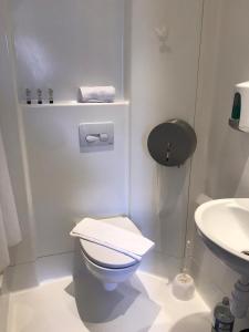 a white bathroom with a toilet and a sink at Brighton Beach Inn in Brighton & Hove