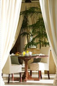 a dining room table with chairs and white curtains at Baraza Resort and Spa Zanzibar in Bwejuu