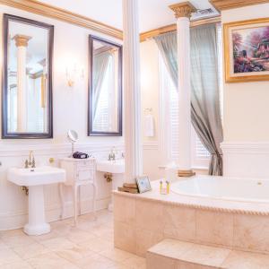 a bathroom with two sinks and a bath tub and a tub at Justine Inn Savannah in Savannah