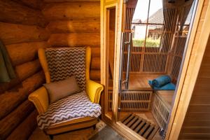 a small porch with a chair in a wooden cabin at Bosorka Apartments Zrub Mara in Liptovský Trnovec