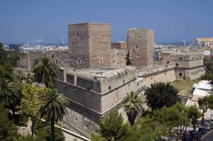 ein altes Gebäude mit Palmen in einer Stadt in der Unterkunft DIMORA CAVALLERIZZA in Bari