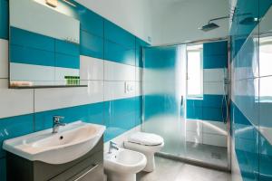 La salle de bains bleue et blanche est pourvue d'un lavabo et de toilettes. dans l'établissement New Fishermans House Seaside, Air conditioning & WI-FI, à Bordighera