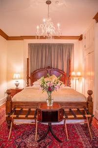 a bedroom with a bed with a vase of flowers on a table at Justine Inn Savannah in Savannah +29 photos