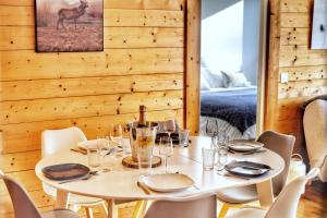 a dining room with a table with chairs and a bed at La Ménandière in Megève