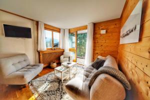 ein Wohnzimmer mit 2 Sofas und einem TV in der Unterkunft La Ménandière in Megève
