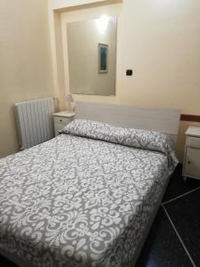 een slaapkamer met een bed met een wit dekbed bij Appartamento Tolemaide in Genua