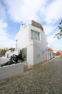 a white house on a cobblestone street at Casa Ameixeira in Ferragudo