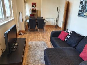 a living room with a couch and a table with chairs at Marina Court LA14 2HL in Barrow in Furness