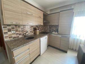 a small kitchen with wooden cabinets and a sink at My Rezidans Hotel in Manisa