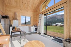 a kitchen with a table and a large glass door at Lake Hawea Owl's Nest - Lake Hawea Holiday Home in Lake Hawea