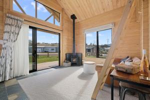 a living room with a fireplace in a wooden house at Lake Hawea Owl's Nest - Lake Hawea Holiday Home in Lake Hawea