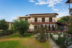 een huis met een balkon en een tuin met bomen bij House Nativa in Mola Kalyva