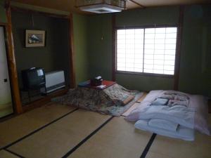 Postel nebo postele na pokoji v ubytování Uotoshi Ryokan + 15 fotografií