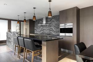 a kitchen with a black counter top and wooden cabinets at Level Yaletown - Richards in Vancouver
