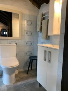ein weißes Bad mit einem WC und einem Stuhl in der Unterkunft El sosiego, der Rückzugsort in Santa Brígida