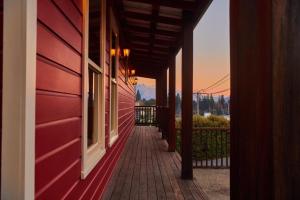 a red building with a walkway next to a building at The Dairy Private Hotel by Naumi Hotels in Queenstown