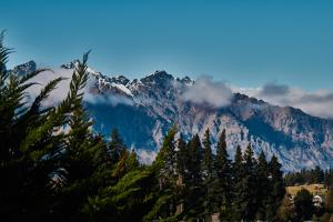 a view of a mountain with trees in the foreground at The Dairy Private Hotel by Naumi Hotels in Queenstown