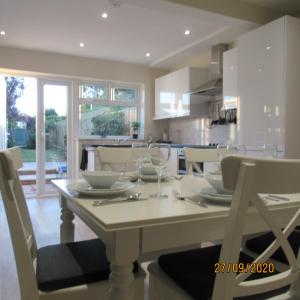 a dining room with a white table and chairs at Merewood House in Oxford