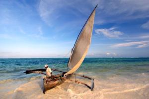 a man in a sail boat on the beach at The Palms Zanzibar in Bwejuu