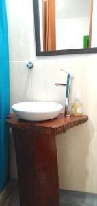 a bathroom with a white sink and a mirror at Hostal Estrella de Agua in Salento