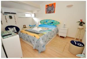 a bedroom with a bed with a blue and yellow blanket at Casinha da Ti Babel in Faro