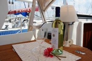 a bottle of wine and a wine glass on a table at Boat & Sailing Torregrande Sinis Yachting in Oristano