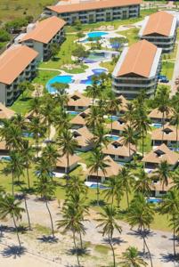 an aerial view of a resort with palm trees at Flat Carneiros Beach Resort in Tamandaré