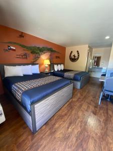 a bedroom with two beds and a painting on the wall at Americas Best Value Inn - Legend's Inn in Junction +37 photos