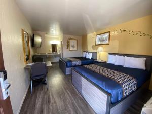 Habitación de hotel con 2 camas y escritorio en Americas Best Value Inn - Legend's Inn, en Junction