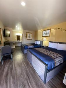 Habitación de hotel con 2 camas y escritorio en Americas Best Value Inn - Legend's Inn, en Junction