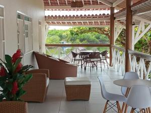 un patio con mesas, sillas, mesa y sillas en Dunas de Marape, en Jequiá da Praia