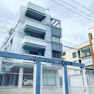 un edificio blanco con un letrero que lee acuario un descanso en Lagoinha Beach Residencial, en Bombinhas