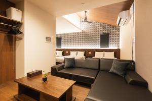 ein Wohnzimmer mit einem Sofa und einem Tisch in der Unterkunft GRAND BASE Hakata Gofuku in Fukuoka