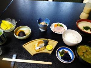 a table topped with plates of food and bowls of food at 縁の宿 北堀 in Matsue